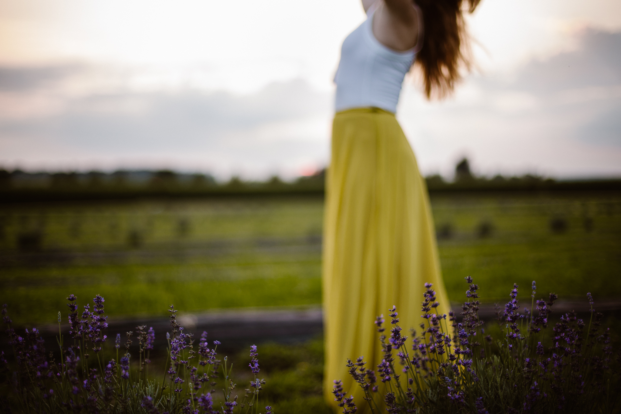 Red headed woman in yellow skirt at sunset in a lavender field.